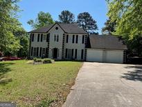 Traditional two-story home with attached two car garage and well maintained landscaping at 1164 Interlaken Pass, Jonesboro, GA 30238