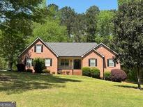 Charming brick home with a well-manicured lawn and mature trees in a serene setting at 75 The Farm Rd, Mcdonough, GA 30252