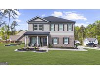 Charming two-story home featuring gray siding, brick accents, and a welcoming front porch with elegant columns at 924 Bryson Lake Cir, Douglasville, GA 30134