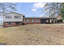 Charming two-story home with brick accents, siding, carport and a spacious front yard at 3727 Calmer Cir, East Point, GA 30344