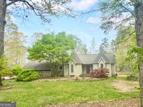 Charming single-story home with a manicured lawn and lush landscaping, creating great curb appeal at 100 Little Creek Dr, Sharpsburg, GA 30277