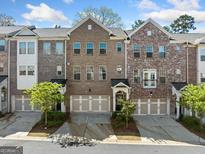 Charming brick townhome featuring an attached garage, well maintained landscaping, and stylish curb appeal at 1341 Rosen Rd, Brookhaven, GA 30319