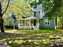 Charming gray home featuring a welcoming front porch and well-maintained lawn at 149 Wimberly Way, Powder Springs, GA 30127