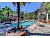 Beautiful in-ground pool surrounded by palm trees, brick accents, and a charming pergola, perfect for relaxation and entertaining at 2230 Cammie Wages Rd, Dacula, GA 30019