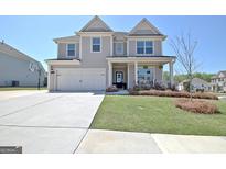 Charming two-story home with a well-manicured lawn, a two-car garage, and a welcoming front porch at 609 Francis Ave, Peachtree City, GA 30269