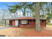 Cozy brick home featuring a covered entry and large front yard with mature tree at 2595 Bonnybrook Sw Dr, Atlanta, GA 30311