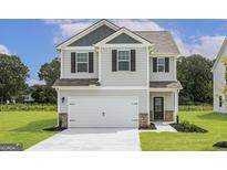 Charming two-story home with a modern gray exterior, attached two-car garage, and well-manicured lawn at 458 Prescott Way, Villa Rica, GA 30180