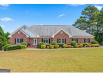 Charming single-story brick home with well-manicured lawn and landscaping, perfect for curb appeal at 103 Wisteria Way, Stockbridge, GA 30281