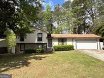 Charming split-level home with stone accents, well-maintained lawn, and an attached two-car garage at 9041 Southcrest Ct, Jonesboro, GA 30238