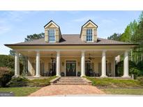 Stately home featuring columns, dormer windows, a symmetrical facade and a welcoming brick walkway and expansive porch at 240 Trotters Rdg, Fayetteville, GA 30215