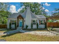 Charming home with bright blue door, white brick chimney, and lush greenery at 3164 Harris Dr, East Point, GA 30344