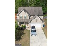 Charming home featuring a 2-car garage, well-maintained lawn, and a welcoming front porch at 6539 Saint Mark Way, Fairburn, GA 30213