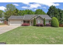Charming single-story home with stone accents, lush lawn, and manicured landscaping at 421 Bear Cub Path, Social Circle, GA 30025