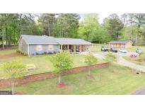 Inviting ranch-style home with spacious front yard, brick wall, manicured landscaping, and a covered front porch at 140 Stoneview Cir, Covington, GA 30016