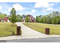 Beautiful brick home with well-manicured lawn, long driveway, and separate garage at 2351 Rabbit Farm Cir, Loganville, GA 30052