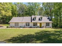 Charming ranch-style home features a well-manicured lawn and inviting curb appeal with ample natural light at 45 Plantation Ln, Locust Grove, GA 30248