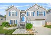 Charming two-story home with a well-manicured lawn, bright blue door and shutters, and a two-car garage at 736 Mesa Rd, Mcdonough, GA 30253