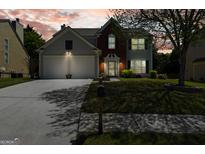 Charming two-story home boasts a well-maintained lawn, two-car garage and classic brick and siding facade at 340 Hammersmith Dr, Suwanee, GA 30024