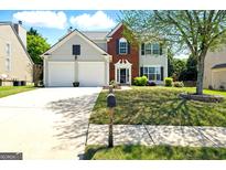 Charming two-story home featuring a brick facade, two-car garage, and a well-manicured front yard at 340 Hammersmith Dr, Suwanee, GA 30024