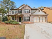 Charming two-story brick home with a well-manicured lawn and a spacious two-car garage at 3541 Stoneleigh Walk, Lithonia, GA 30038
