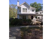 Charming two-story home featuring a covered front porch, light gray siding, and manicured landscaping at 1232 Memorial Se Dr, Atlanta, GA 30316