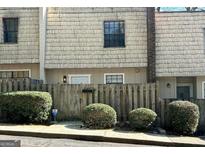 Charming townhouse featuring a wood fence, mature bushes, and a well-maintained shingle facade at 1331 Woodstone Trce, Morrow, GA 30260