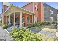 Charming brick house featuring a covered porch with ceiling fans and landscaped yard at 175 Central Ave, Fayetteville, GA 30214