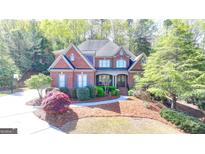 Beautiful brick home with manicured landscaping and a welcoming front porch at 10125 Brixton Pl, Suwanee, GA 30024