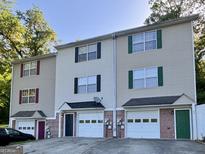 Multi-Gathering townhouse with attached garages, vinyl siding, and colorful accent doors and shutters at 33 Corinth Rd, Cartersville, GA 30121