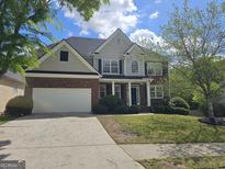 Charming two-story home with a brick and siding exterior, attached garage, and well-maintained lawn at 6281 Vinings Vintage Dr, Mableton, GA 30126