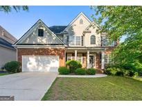 Charming two-story brick and siding home with manicured lawn and attached two-car garage at 6281 Vinings Vintage Dr, Mableton, GA 30126