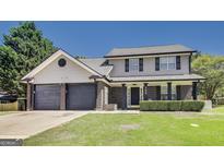 Charming two-story home featuring a two-car garage and a well-manicured front lawn at 200 Tait Rd, Stockbridge, GA 30281