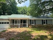 Charming single-story home with green siding, stone foundation, and a well-maintained front yard at 30 Laurel Way, Covington, GA 30016