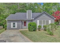 Charming single story home with a well-manicured lawn, beautiful landscaping, and a gray exterior at 322 Wood Rdg, Peachtree City, GA 30269