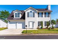 Charming two-story home features a two-car garage and a well-maintained front yard at 2554 Willenhall Way, Lithonia, GA 30058