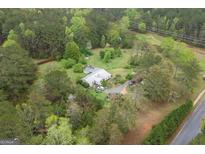 A captivating aerial view of a secluded home nestled among lush greenery with a winding driveway and a private pool at 24 Shiloh Church Rd, Carrollton, GA 30116