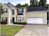 Charming two-story home featuring a well-manicured lawn and attached two car garage at 220 Camerons Way, Covington, GA 30016