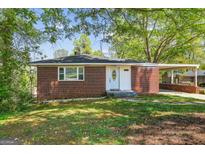 Charming brick home with a well-manicured lawn, a carport, and a welcoming front entrance at 1254 South Enota, Gainesville, GA 30215