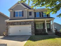 Charming two-story home boasts stone accents, gray siding, and a well-maintained front lawn at 1007 Oglethorpe Ct, Woodstock, GA 30188