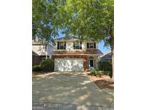 Charming two-story home with brick accents, attached garage, and mature trees at 403 Buckboard Ln, Locust Grove, GA 30248