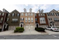 Charming multi-colored townhomes, featuring a beige townhome in the center, each with a front-entry garage and manicured landscaping at 6089 Indian Wood Se Cir, Mableton, GA 30126