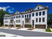 Charming townhomes featuring a light exterior, garage, and manicured landscaping at 3028 Pruitt Ln, Smyrna, GA 30080