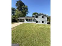 Charming two-story home featuring a well-manicured lawn and a convenient carport at 6505 Allatoona Rd, Morrow, GA 30260