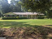 Charming brick ranch home with large front yard and mature landscaping at 2215 Mount Carmel Rd, Hampton, GA 30228