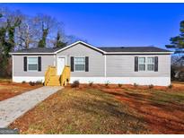 Charming single-story home with gray siding, black shutters, and a new wood porch and walkway at 36 Highpoint Ln, Locust Grove, GA 30248