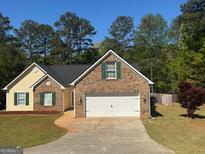 Charming brick and siding home featuring a two-car garage and well-manicured lawn at 365 Lamar Ln, Covington, GA 30016