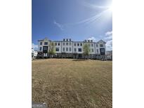 A modern multi-Gathering building with white siding, black trim, and a landscaped front lawn on a sunny day at 1117 Larkin Dr, Buford, GA 30518