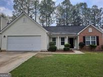 Charming single-Gathering home featuring mixed brick and vinyl siding, a two-car garage, and a well-maintained lawn at 114 Revere Turn, Fairburn, GA 30213