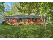 Charming red brick home with well-maintained lawn and mature trees shading the front yard at 172 W Campbellton St, Fairburn, GA 30213