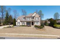 Charming brick and stone two-story home with a well-manicured lawn and inviting front porch at 2358 New Salem Trce, Marietta, GA 30064